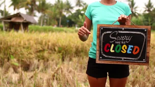 Woman hands with closed sign board on a tropical nature background. Bali island. — Stock Video