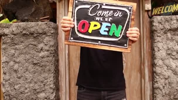 Open sign board in a man hands on a tropical nature background. Shooted on Bali island, full HD. — Stock Video