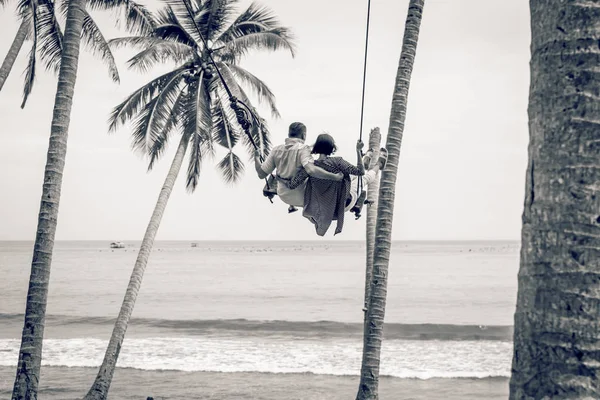 Jong koppel swingen op het tropische strand van Bali eiland, Indonesië. — Stockfoto