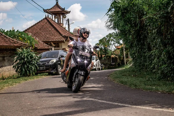 BALI, INDONESIA - DECEMBER 26, 2018: Pasangan muda mengendarai skuter di hutan hujan, pulau Bali . — Stok Foto