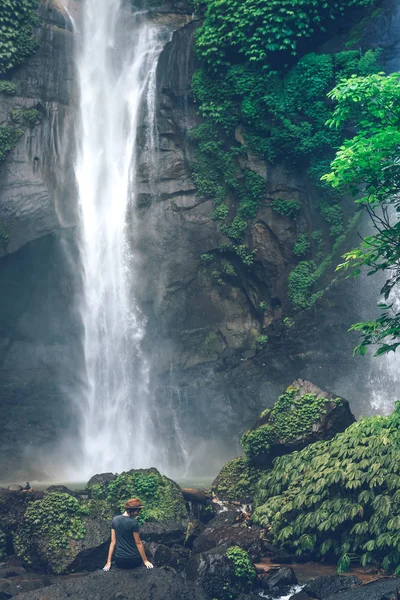 Young woman posing on a great Sekumpul waterfall in the deep rainforest of Bali island, Indonesia. — стокове фото