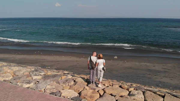 4k antenn drönare flyger bilder av unga par på den vilda svarta sandstranden. Ön Bali. — Stockfoto