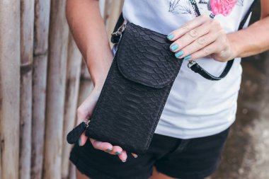 Genç kadın elle şık lüks yılan derisi python çanta açık havada. Bali Adası.