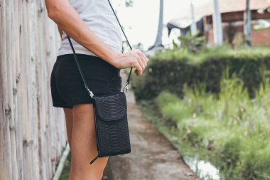 Genç kadın elle şık lüks yılan derisi python çanta açık havada. Bali Adası.