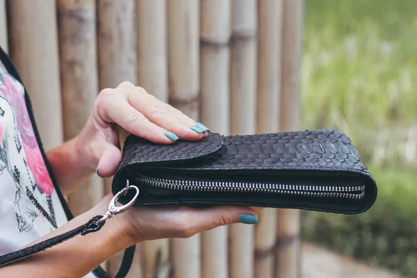 Genç kadın elle şık lüks yılan derisi python çanta açık havada. Bali Adası.