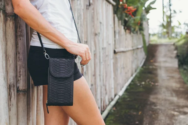 Genç kadın elle şık lüks yılan derisi python çanta açık havada. Bali Adası.