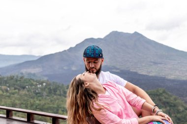 Bali, Endonezya - 3 Ocak 2019: Genç balayı çift üzerinde bir yanardağ Batur arka plan.