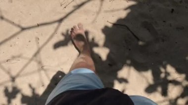 Çıplak ayakla kumlu tropikal plaj Bali üzerinde yürüyen adam 