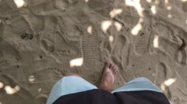 Çıplak ayakla kumlu tropikal plaj Bali üzerinde yürüyen adam 