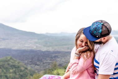 Bali, Endonezya - 3 Ocak 2019: Genç balayı çift üzerinde bir yanardağ Batur arka plan.