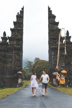 Genç balayı iki büyük balinese kapı arka plan üzerinde. Bali Adası, Endonezya.