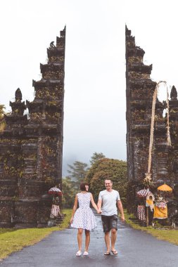 Genç balayı iki büyük balinese kapı arka plan üzerinde. Bali Adası, Endonezya.