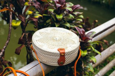 Şık el yapımı rattan Eko dostu el çantası tropikal bir arka plan üzerinde. Bali Adası.