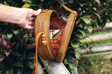 Şık el yapımı rattan Eko dostu el çantası tropikal bir arka plan üzerinde. Bali Adası.