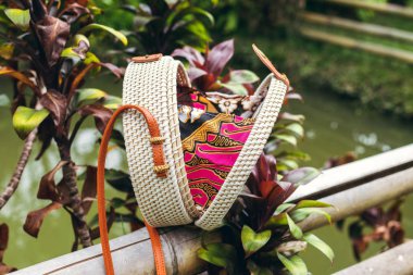 Şık el yapımı rattan Eko dostu el çantası tropikal bir arka plan üzerinde. Bali Adası.