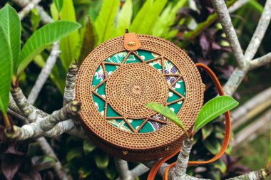 Şık el yapımı rattan Eko dostu el çantası tropikal bir arka plan üzerinde. Bali Adası.