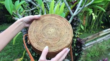 Tropikal bir arka plan üzerinde şık el yapımı rattan el çantası closeup. Bali Adası.