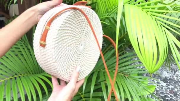 Primer plano de elegante bolso de ratán hecho a mano sobre un fondo tropical. Isla de Bali . — Vídeo de stock