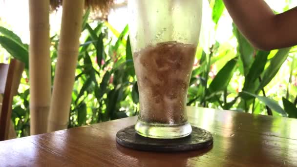 Menuang minuman ringan cola dengan es di latar belakang tropis, pulau Bali . — Stok Video