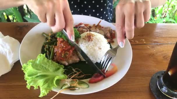 Mujer comiendo filete de atún barbacoa en un café tropical de la isla de Bali, Indonesia . — Vídeos de Stock