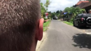 Bali dili bir sokakta adam sürme motosiklet scooter. Bali, Endonezya'nın tropik ada.