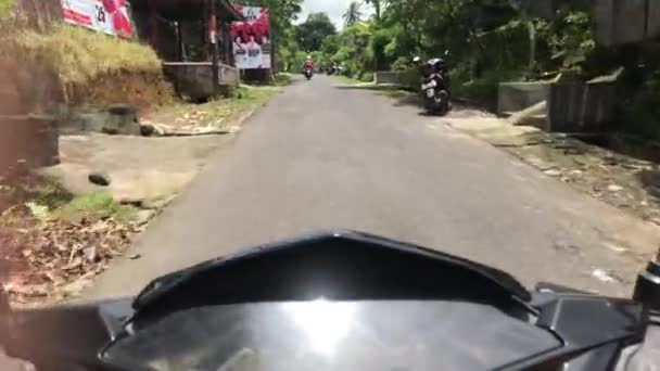 BALI, INDONESIA - 9 de febrero de 2019: Hombre montando moto scooter en una calle balinesa . — Vídeo de stock