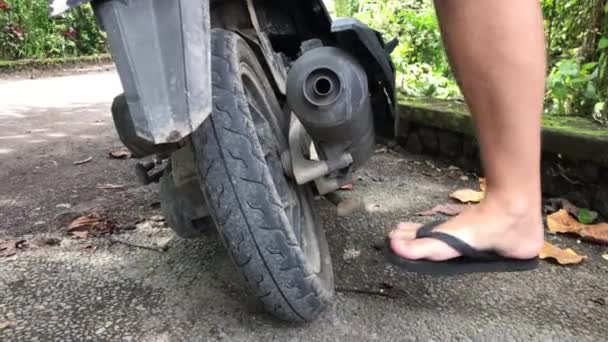 Detailní video člověka kontrola motorka scooter pneumatiky na ulici Ubud, ostrova Bali, Indonésie. — Stock video