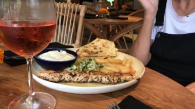 Tavuk souvlake Yunan et kebap restoranı olan kadın.