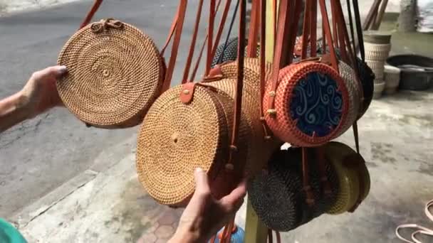 Vrouw kiezen rotan eco tassen in de kunstwinkel op Bali eiland, Indonesië. Stijlvolle eco-bag voor vrouw. — Stockvideo