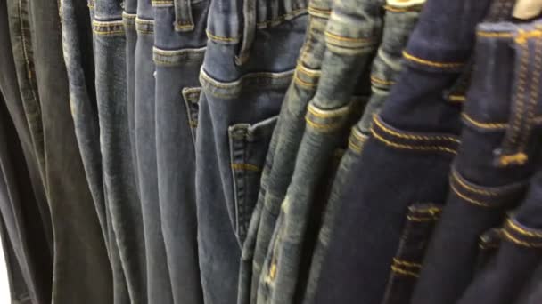 Close up van veel jeans in de winkel. 4 k-beeldmateriaal in het winkelcentrum. — Stockvideo