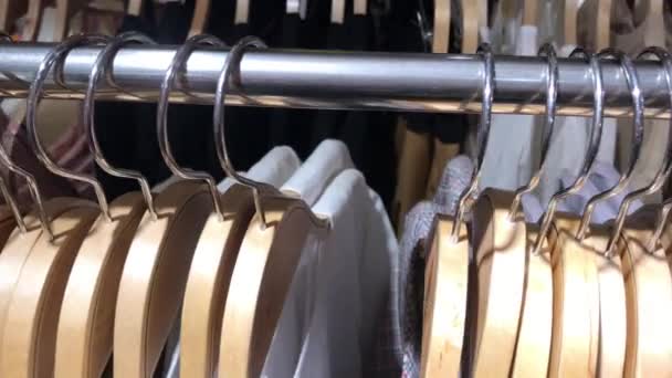 Closeup of metal hangers in the store. Shopping mall. 4K footage. Fashion store, retail. — Stock Video