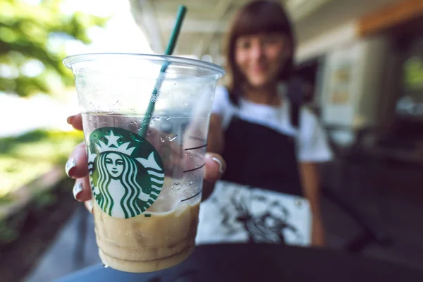 Bali, Indonézia - Febraury 19, 2019: Nő a jeges latte a Starbucks. A Kuta, Beachwalk shopping mall. — Stock Fotó