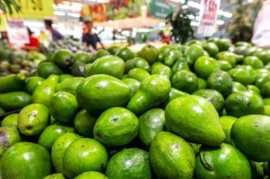 Yerel bir gıda pazarında taze organik egzotik yeşil avokado, Bali Adası. Avokado arka plan.