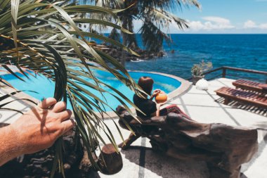 Yaz aylarında yüzme havuzunda rahatlatıcı Hindistan cevizi olan kadın. Bali Adası, Endonezya tatil.