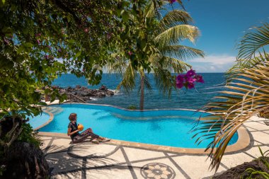 Yaz aylarında yüzme havuzunda rahatlatıcı Hindistan cevizi olan kadın. Bali Adası, Endonezya tatil.