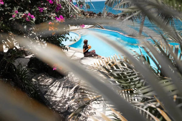 Mujer joven con coco relajándose en la piscina en verano. Vacaciones en la isla de Bali, Indonesia . — Foto de Stock