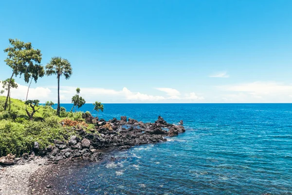 Dream island. Wild tropical beach with rocks and contrast blue sky. Bali island.