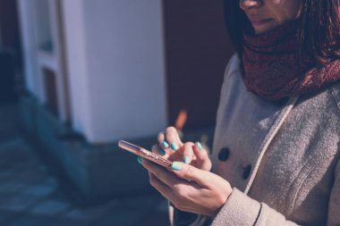 Bir şehir parkında bir akıllı telefon kullanan mutlu kız. Moscow, Rusya Federasyonu.