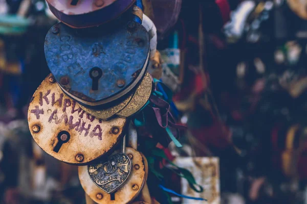 Primer plano de una cerradura de amor en una barandilla en un puente de cerraduras con otras cerraduras borrosas para crear un fondo bokeh . — Foto de Stock