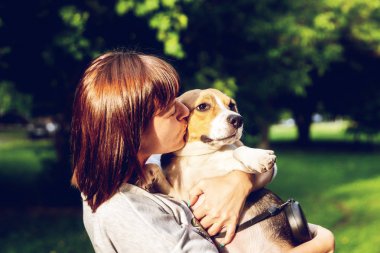 Genç kadının portre onu sevimli Beagle köpek öpüşme. Aşk, mutlu, öpüşme yavrusu.