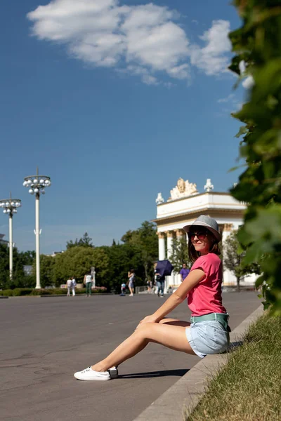 Mujer con sombrero sentada en la frontera en el parque, Moscú . —  Fotos de Stock