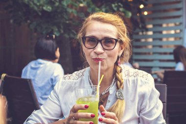 Açık restoranda kokteyl ile Orta yaş güzel kadın.