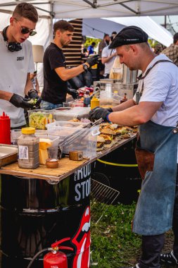 Moskova, Rusya - 27 Temmuz 2019: Johncalliano nargile festivalinde barbekü burger pişiren bir grup erkek.