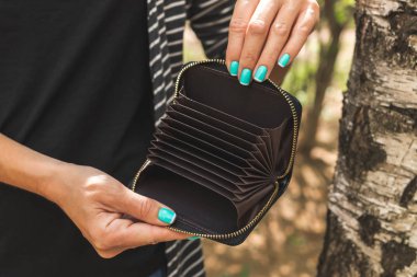 Doğa arka planda küçük cüzdan kart sahibi ile genç kadın eller.