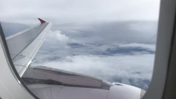 Vista del cielo azul y las nubes a través de la ventana de la aeronave, Primer plano Ventana del avión con ala de avión, Concepto de viaje . — Vídeo de stock