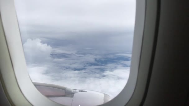 Vista del cielo azul y las nubes a través de la ventana de la aeronave, Primer plano Ventana del avión con ala de avión, Concepto de viaje . — Vídeos de Stock