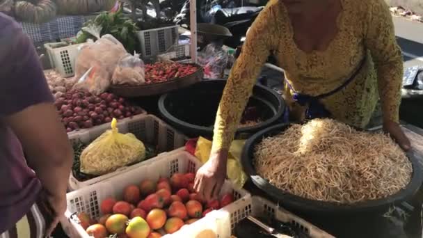 Bali, Indonesië-21 februari 2019: vrouw die groenten verkoopt op een lokale biologische markt. — Stockvideo