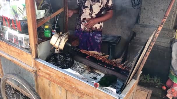 BALI, INDONÉSIA - FEVEREIRO 21, 2019: Cozinhar sate ayam. Comida de rua indonésia tradicional, frango frito . — Vídeo de Stock