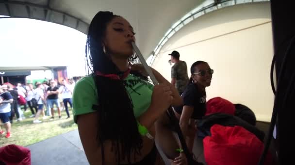 MOSCOW, Ryssland - 27 juli 2019: Ung svart kvinna röker hora på festivalen. Långsamma rörelser. — Stockvideo