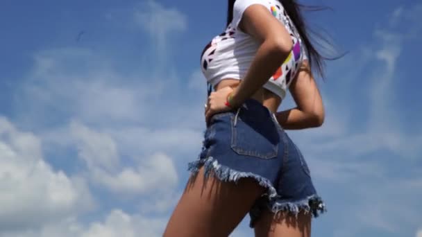 MOSCOW, RUSSIA - LIPIEC 27, 2019: Młoda kobieta w krótkich seksownych spodenkach tańczy na festiwalu. — Wideo stockowe